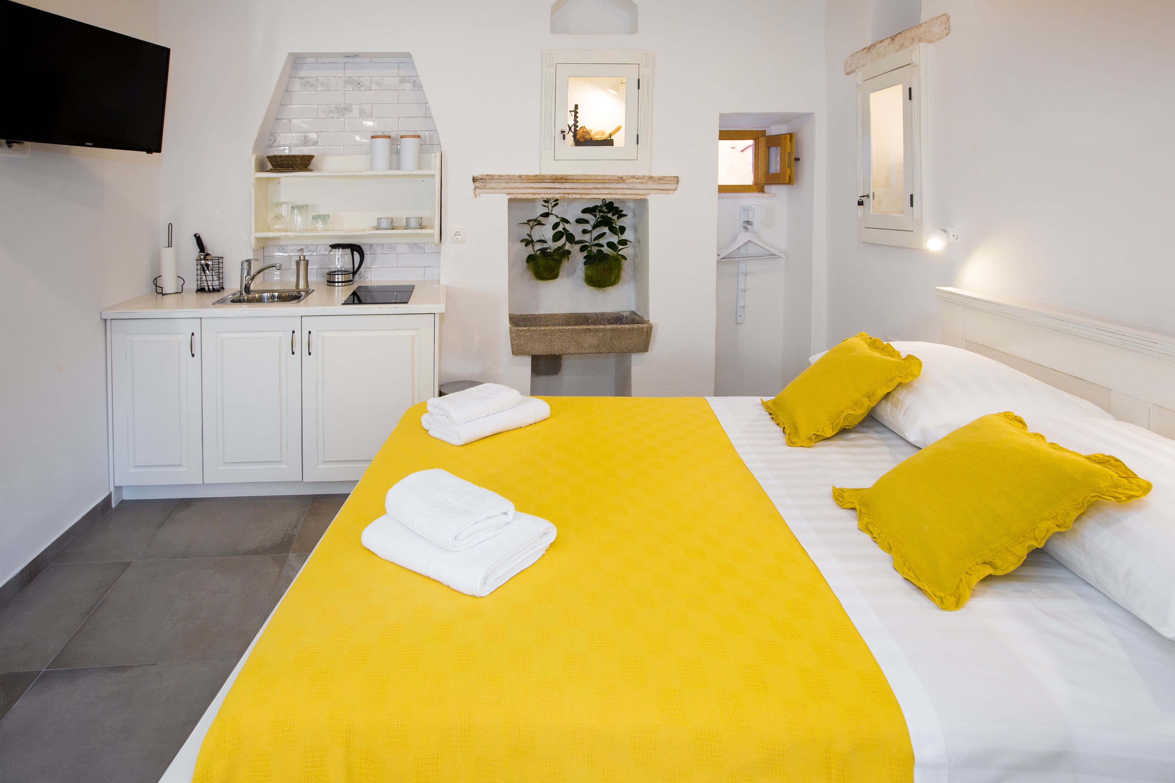 Une chambre d’hôtel avec un lit, un lavabo et un miroir.