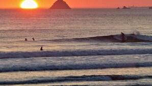 A sunset over the ocean with waves and a distant island. - Comfortable family home a stone's throw from the GR34 and beaches (Crozon)