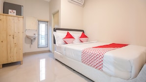 Un dormitorio con una cama, un armario de madera, un lavabo blanco y un equipo de aire acondicionado.