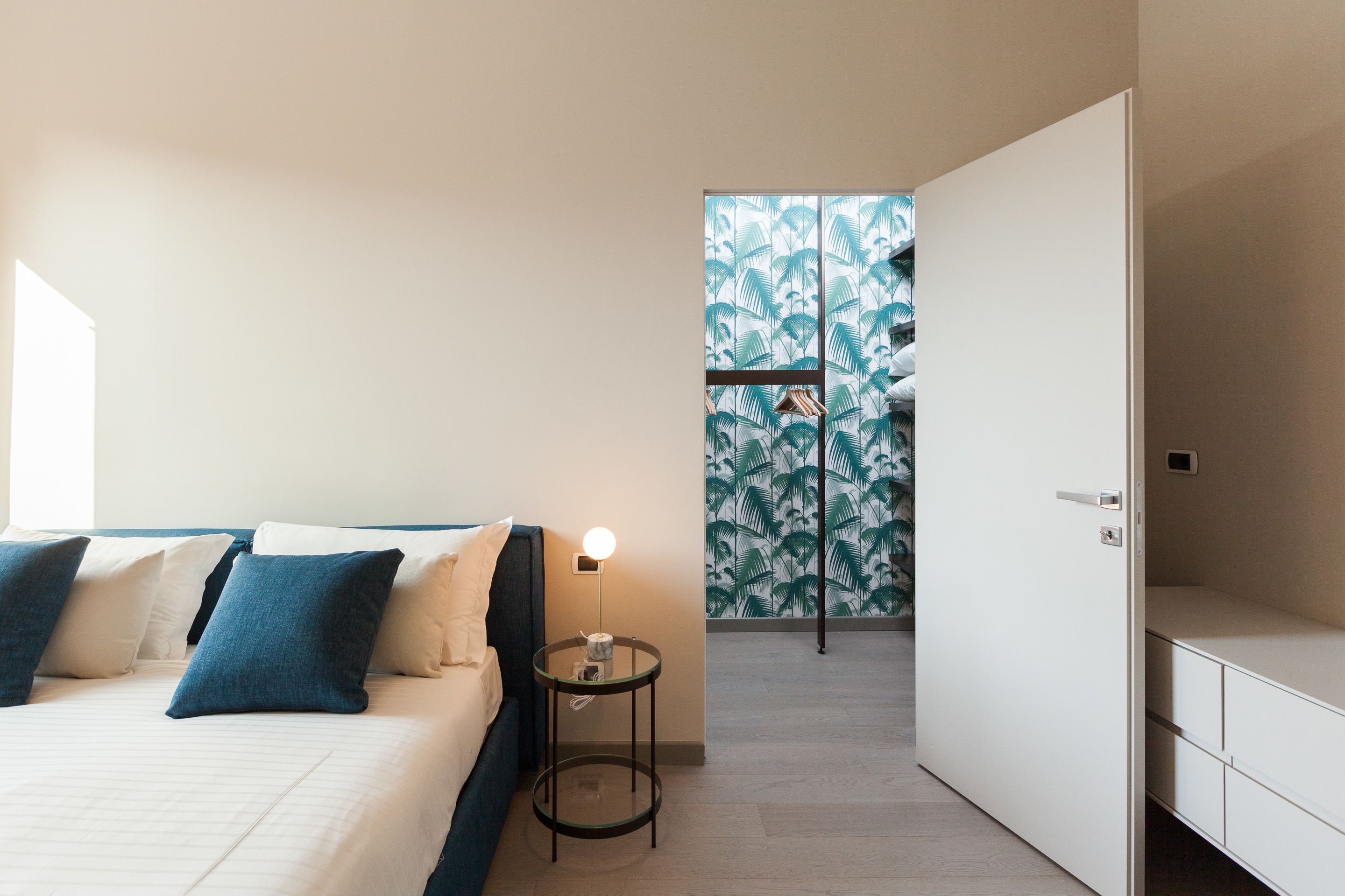 Een slaapkamer met een bed, nachtkastje en garderobe.