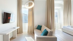 Una habitación de hotel moderna con televisión de pantalla plana, un sofá, una cama y un escritorio.