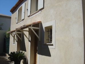 Un immeuble de deux étages doté d’un balcon et d’une petite fenêtre ornée d’une grille en métal.
