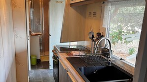 A compact kitchen with a sink, stove, and cabinets. - Mobile home in Figari at the Hamlet of San Gavino (Figari)