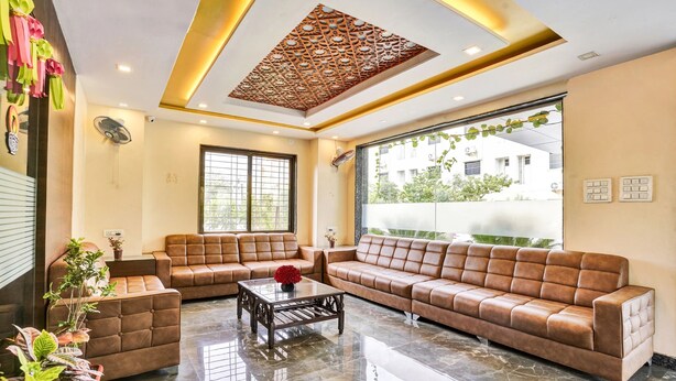 Eine moderne Lobby mit Ledersofas, einem Marmorboden und großen Fenstern mit Blick ins Freie.