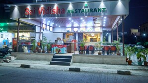 Ein Restaurant namens Sai Vidisha mit Außenbereich und Blumentöpfen.