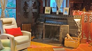 A cozy living room with a fireplace, a comfortable armchair, and a wooden sideboard. - Comfort, Charm and Tradition at once (Erdenheim)