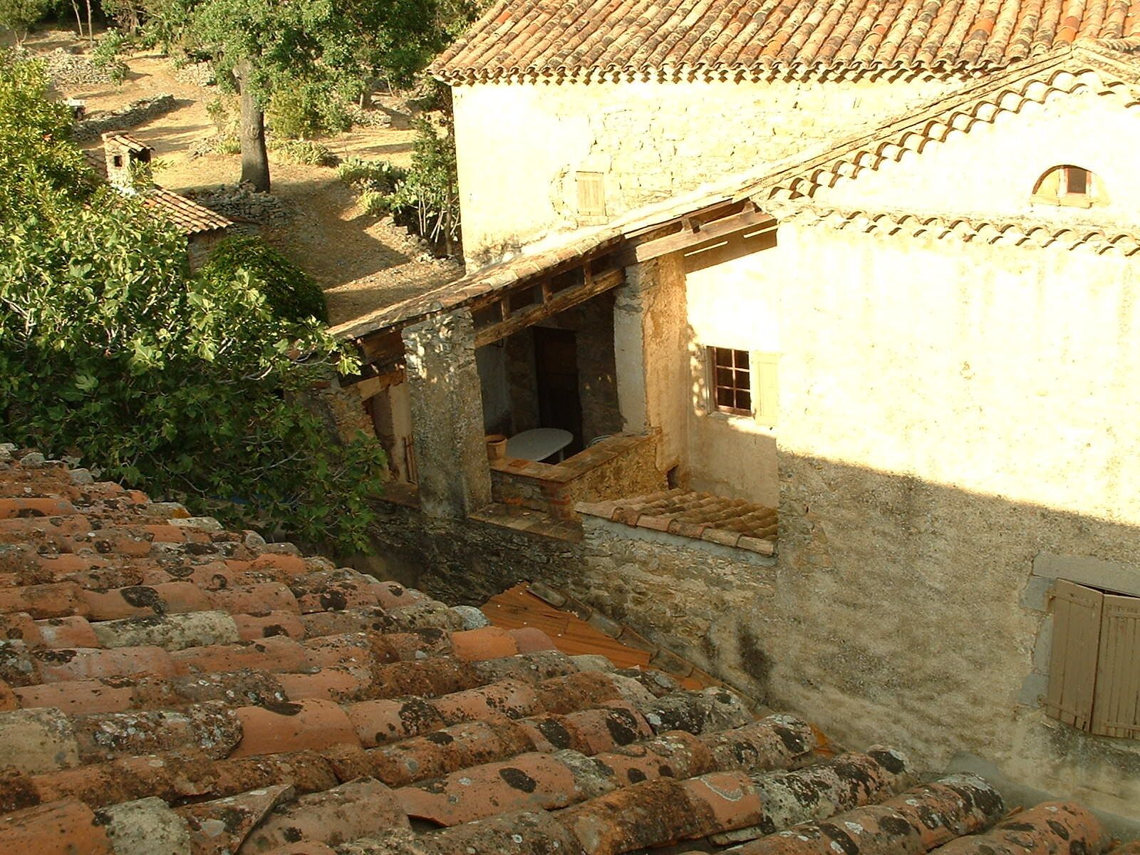 Un edifici rústic amb teulada d'àmples rajoles i una petita finestra.
