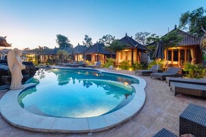Una piscina al aire libre, tumbonas