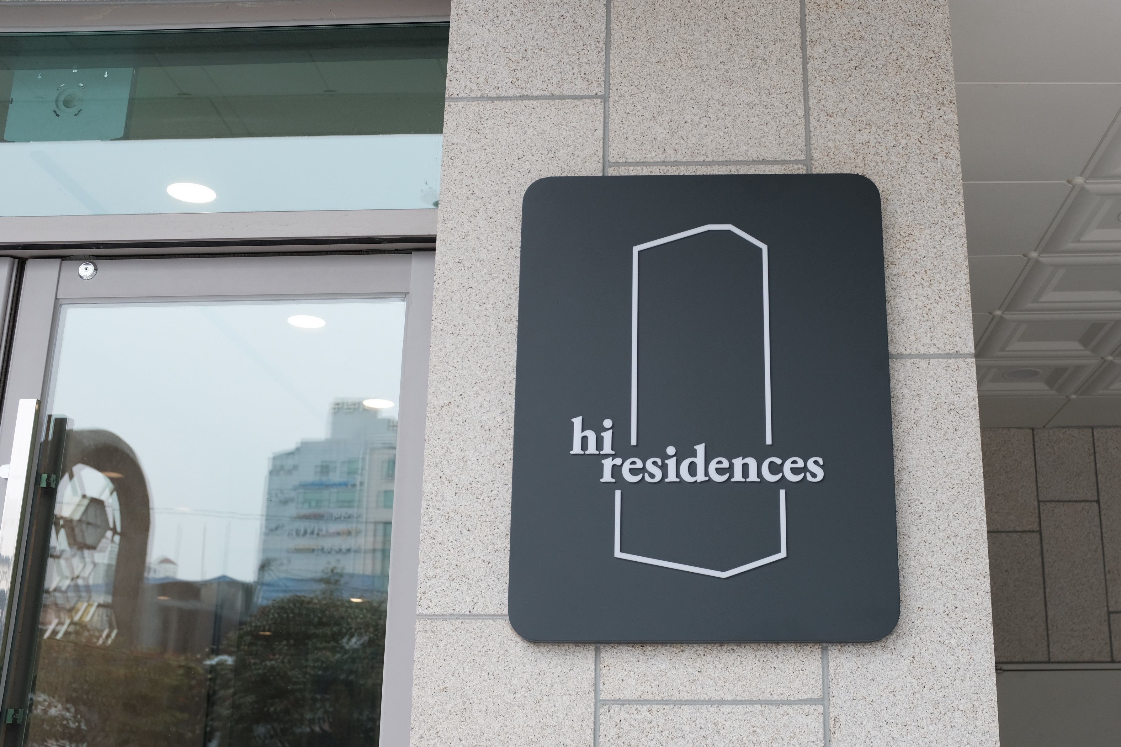 Une enseigne avec l’inscription « hi residences » sur la façade d’un immeuble.