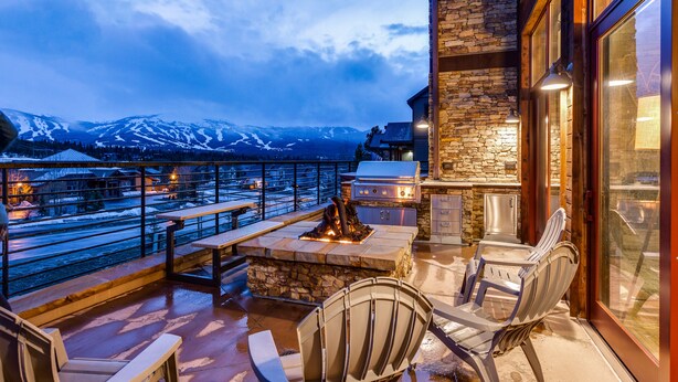 Une terrasse extérieure avec un sol en pierre, un barbecue et des sièges.