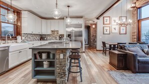 Une cuisine moderne dotée d’un îlot central, de tabourets de bar et d’un coin repas comprenant un canapé et une table.