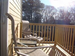 Relax on the deck with a view of the surrounding trees and sky from two comfortable chairs.