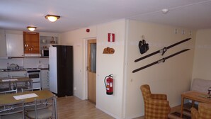 A compact living space with a kitchen, dining area, and a small seating area. - Sopperogården - Hostel (Övre Soppero)