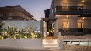 A modern building with a well-lit entrance, a balcony, and a staircase leading to the entrance. - Sun Ray Luxury Apartments (Chania)