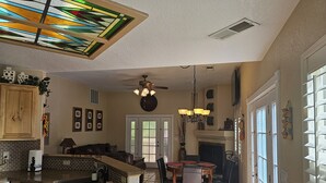 A kitchen with a large island, a dining area with a table and chairs, and a fireplace. - Cozy Sedona Get-Away (Sedona)