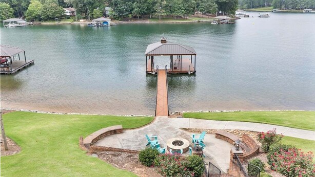 A lakeside property with a gazebo, dock, and outdoor seating area.