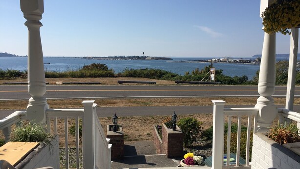 A porch with a view of the ocean and a road. - Amazing sunset in front of historic house  (Blaine)