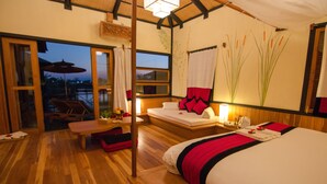 A room with a bed, a small table, a bench, and a window. - Inle Heritage Stilt House (Nyaungshwe)
