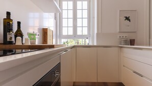Eine moderne Küche mit weißen Schränken, einer Holzarbeitsplatte und einem Fenster mit weißen Rahmen.