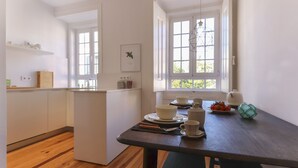 Eine moderne Küche mit weißen Schränken, einem Holztisch und einem Fenster mit Blick.