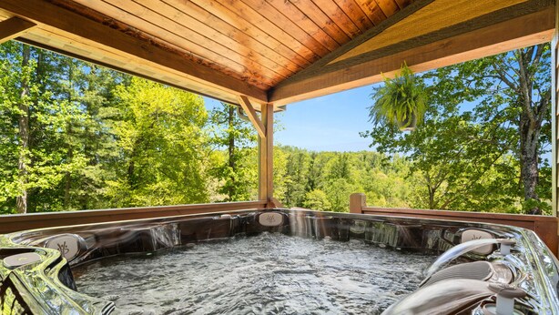 A hot tub with a wooden roof and a view of a forest. - 2019 Newly Built ~ LUXURY Cabin ~ 23 Acre Estate ~ Hot Tub ~ 8 miles to Downtown (Asheville)