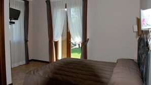 A bedroom with a bed, a television, and curtains. - Locanda dei Rii (Manerba del Garda)