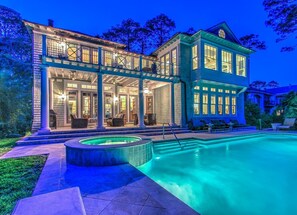 A large, two-story house with a swimming pool, featuring a covered patio area with outdoor seating and a hot tub. - Top of the Line Luxury Ocean Front Home (Hilton Head Island)