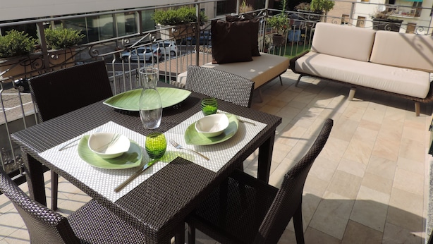 A balcony with a dining table set for two, outdoor furniture, and a sofa. - Luxury apartment located 500 metres from  historic centre and railway station (Varese)