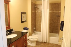 Een bad/douchecombinatie, een haardroger, handdoeken