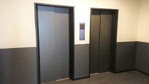 A hallway with two closed elevator doors and a control panel above them. - Hotel Chuo Bridge (Osaka)