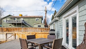 A deck with a table and chairs, a grill, and a wooden fence. - Beautiful Home in Willits! (Basalt)
