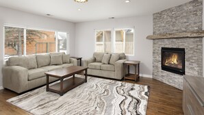 A modern living room with a fireplace, a sofa, a coffee table, and a rug. - Beautiful Home in Willits! (Basalt)