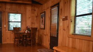 A wooden interior with a dining table, chairs, and a bench.