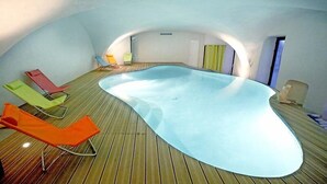 An indoor swimming pool with wooden flooring and colorful lounge chairs. - Le Moulinage (Saint-Thomé)