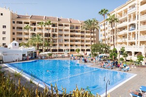 Una piscina al aire libre, tumbonas