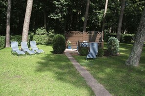 A pathway leading to a seating area with two lounge chairs and a bench. - Appartementpark Seeblick (Plau am See)