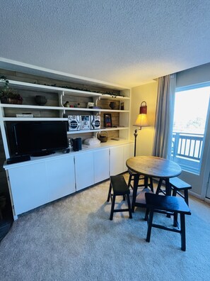 Enjoy a compact living space with a kitchenette, dining area, and large window offering a view of the outdoors.