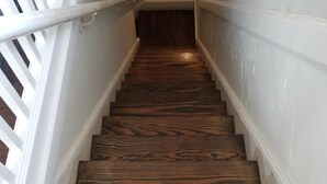 Eine Holztreppe mit weißen Geländern und Wänden.