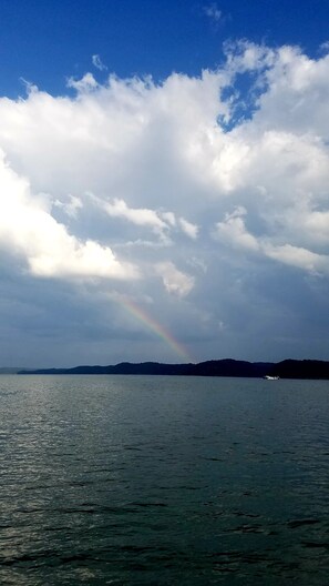 A body of water with a rainbow and a distant boat. - Lake Cumberland Hideaway #1-2 miles from Jtown Marina! Boat Parking & Fire Pit! (Jamestown)