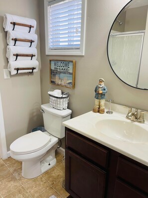 A bathroom with a toilet, sink, and a towel rack with folded towels. - Lake Cumberland Hideaway #1-2 miles from Jtown Marina! Boat Parking & Fire Pit! (Jamestown)