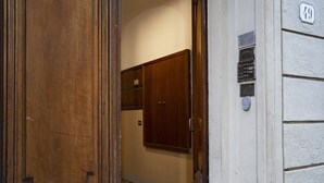 Eine Holztür mit Griff, ein gefliester Boden und ein an der Wand befestigter Briefkasten.