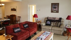 A living room with two sofas, a coffee table, and a dining area with a table and chairs. - 2B Condo w/ Game Tables and Great Views! (Sugar Mountain)