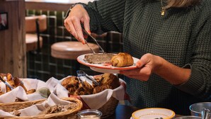 A person serving food at a table with various dishes and condiments. - Hôtel de Verbier SUP (Bagnes)
