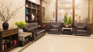 A modern living room with leather sofas, a coffee table, and a bookshelf. - Western Hanoi Boutique Hotel (Hanoi)