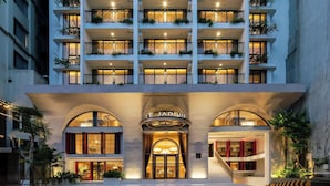 Ein mehrstöckiges Hotel mit Balkonen, einem zentralen Atrium und einem Restaurant im Erdgeschoss.