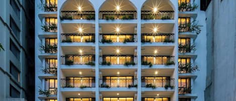 A multi-story hotel with balconies, a central atrium, and a restaurant at the ground level.