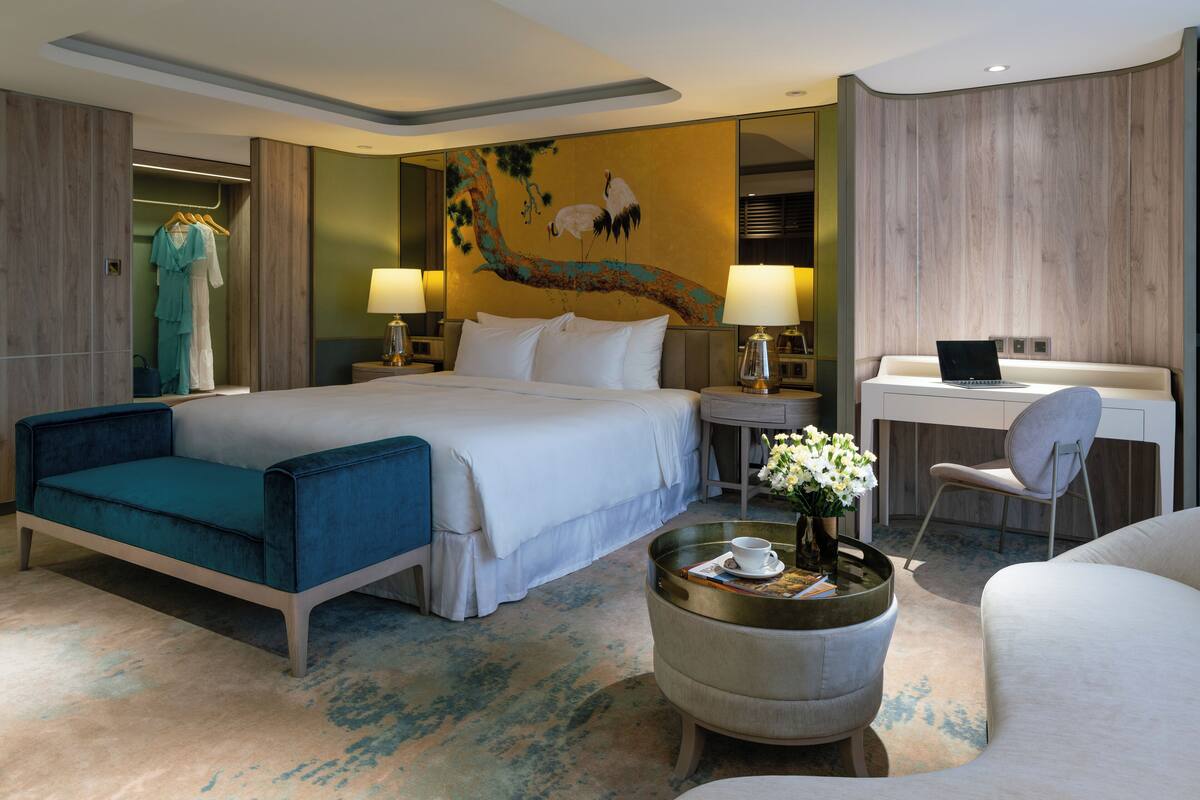 Une chambre d’hôtel moderne dotée d’un grand lit, d’un bureau et d’un coin salon.
