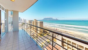 Ein Balkon mit Blick auf Strand und Meer.