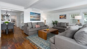 A modern living room with a grey sofa set, a wooden coffee table, and a patterned rug.
