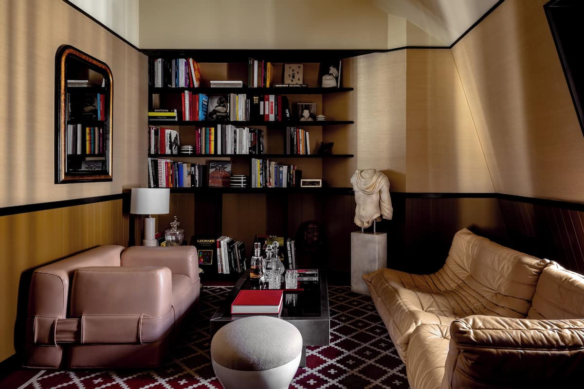 Una sala de estar moderna con un sofá, una mesa de centro y una estantería llena de libros.